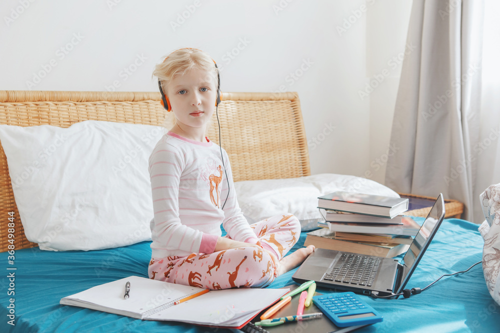 Caucasian girl child learning online on laptop Internet. Virtual class school on video call during self isolation quarantine at home. Distant remote education class. A new normal and homeschooling.