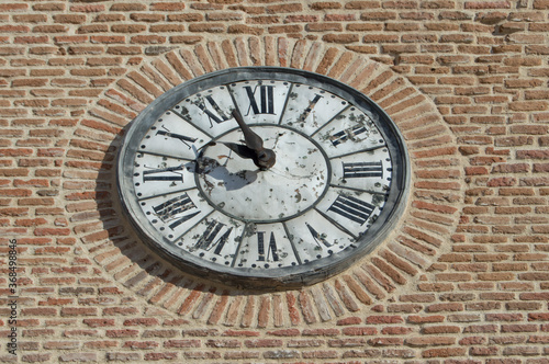 old clock with roman numerals isolated on a brick wall