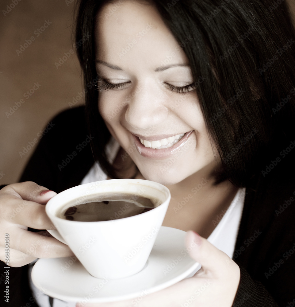 young woman sitting in a cafe drinking coffee