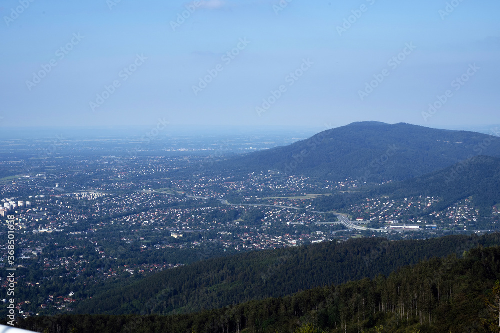 Bielsko Biala, South Poland: Wide angle from up above panoramic detailed high definition view of scenic mountains, green forest and city against blue sky
