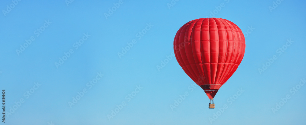 Obraz premium Hot air balloon in blue sky, space for text. Banner design