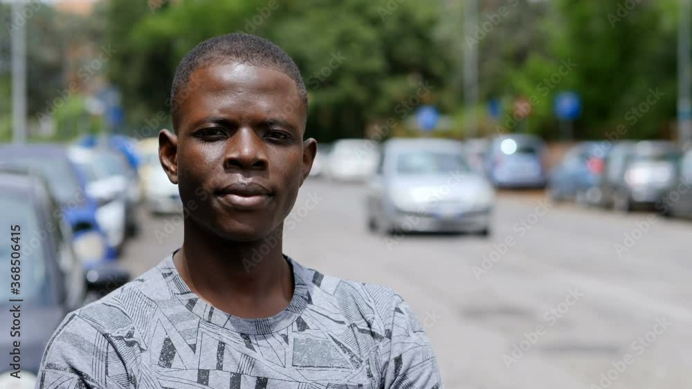 young serious black man on the street in a sunny day looking at camera young serious black man on the street in a sunny day looking at camera