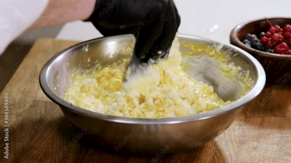 Close up of male hands in black gloves mix the yolk eggs and cottage cheese in a bowl. 4K Close up of male hands in black gloves mix the yolk eggs and cottage cheese in a bowl. 4K