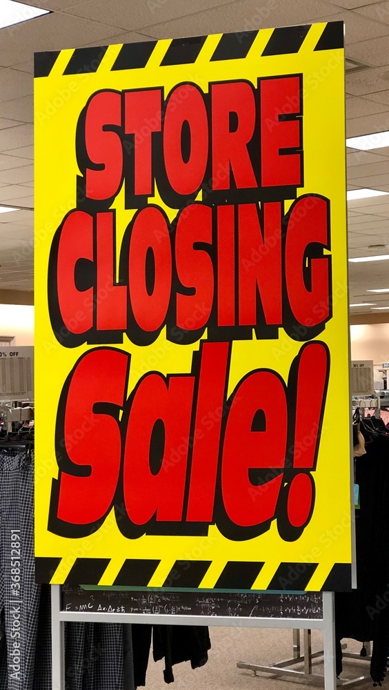 Yellow and red store closing sign is displayed at a retail store that
