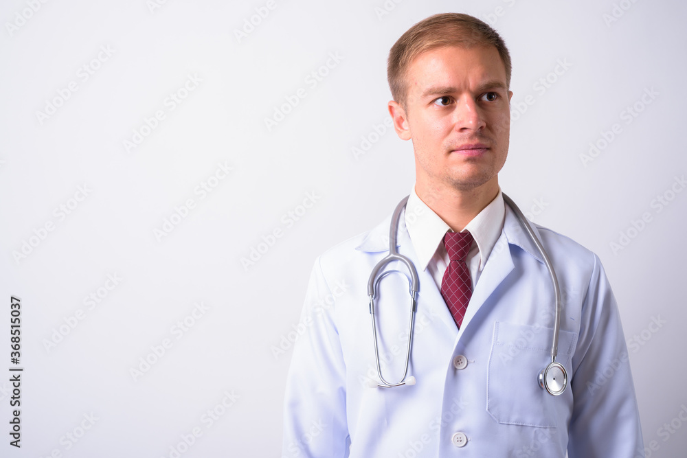 Fototapeta premium Portrait of handsome man doctor against white background
