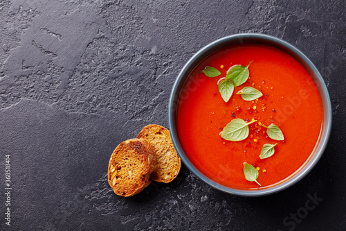 Obraz na plátně Tomato soup with basil in a bowl