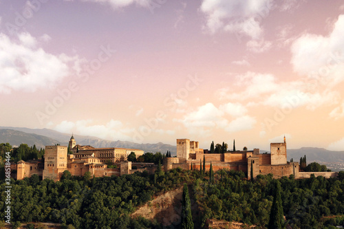 Granada landscape at sunset  with the Alhambra  the mountains in the background  trees and the sky with clouds for a nice postcard or wallpaper