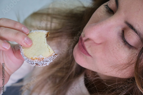 woman eating cornstarch alfajor and drinking yerba mate infusion