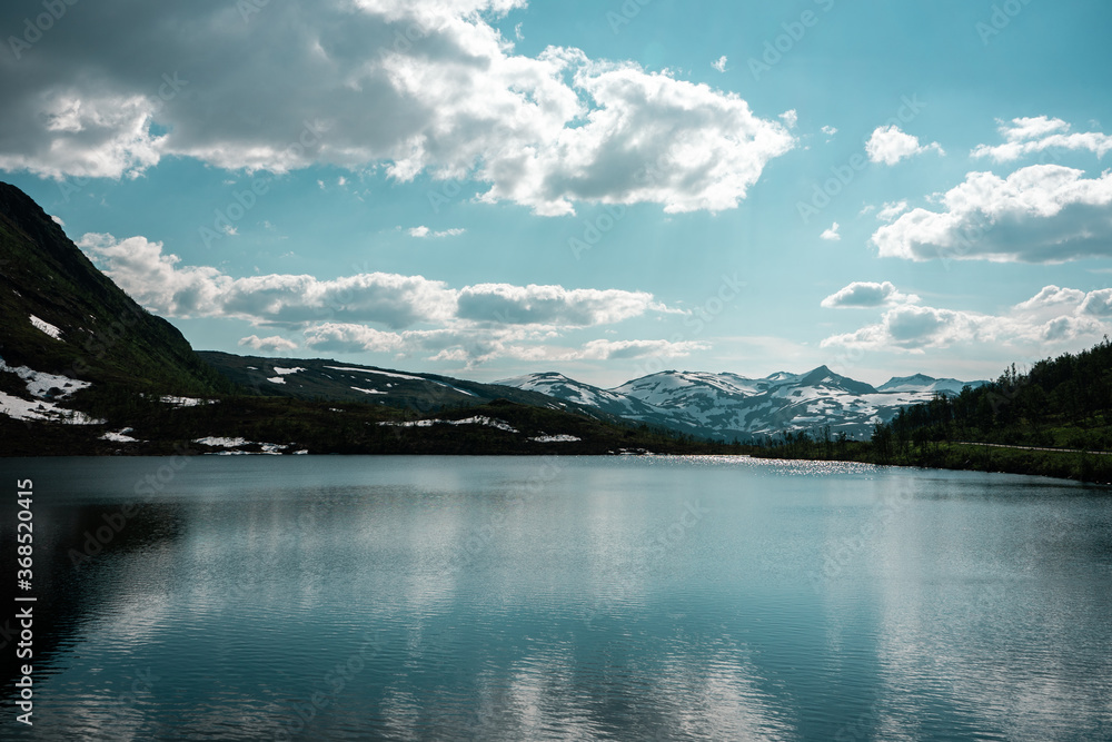 Natural scandinavian beautiful landscape. Glacial lake, fiord, snowy mountains. Sunny day in nortnern Norway. 