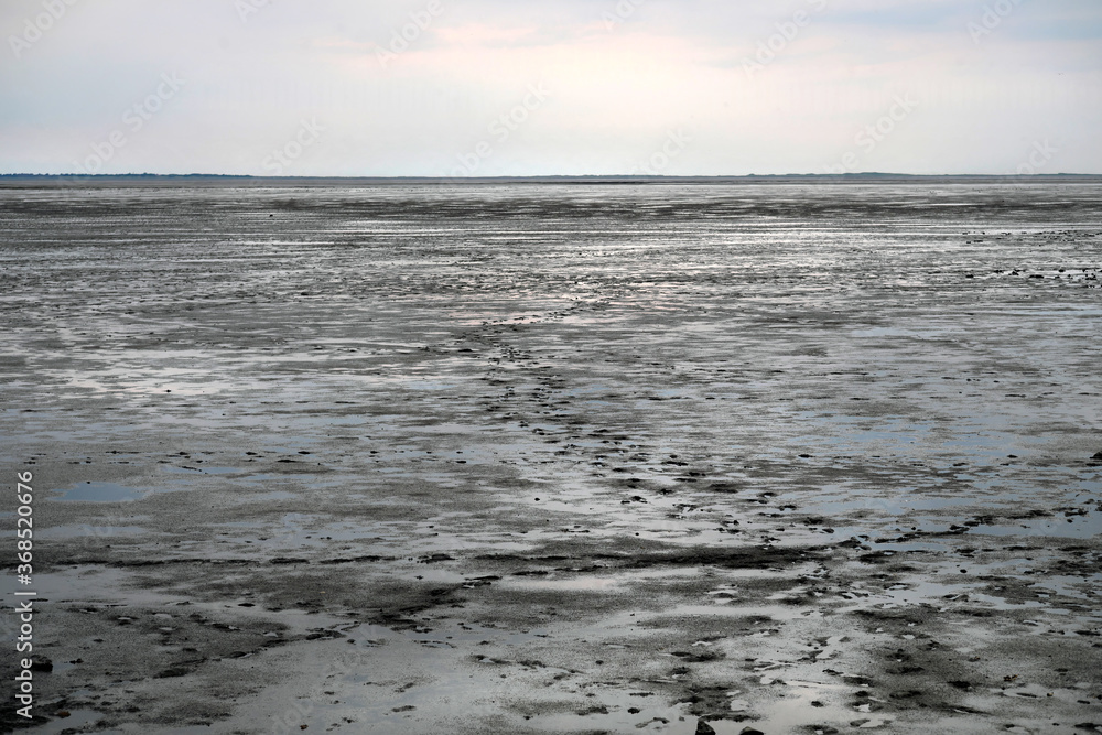 Das Wattenmeer an der Nordsee bei Ebbe mit Fußspuren im Schlick - Stockfoto
