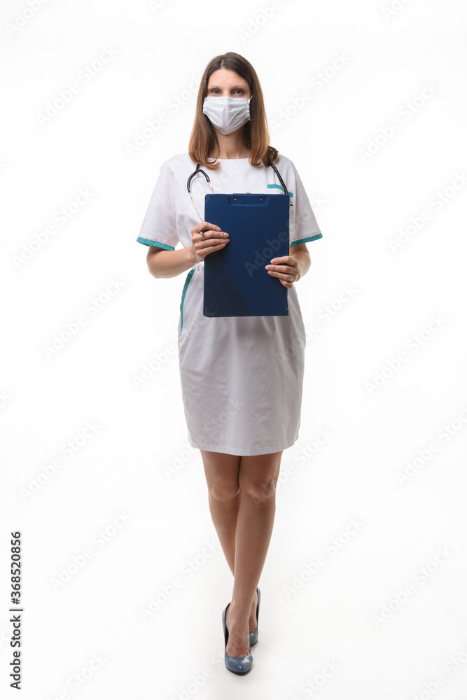 Fototapeta premium girl doctor in medical clothes and mask with tablet in hand on white background
