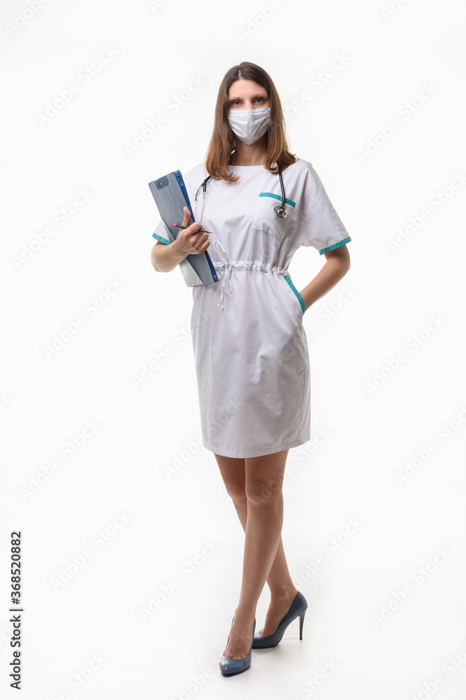 Girl in medical clothes and mask posing with tablet on white background Girl in medical clothes and mask posing with tablet on white background