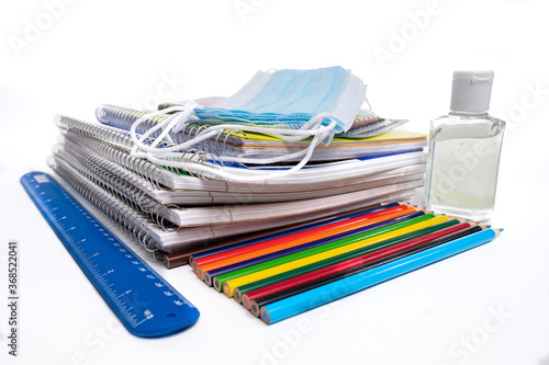 Wallpaper Mural Stack of school supplies including Covid 19 face masks on a white background Torontodigital.ca