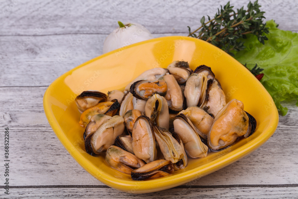 Pickled mussels in the bowl served pepper, garlic and salad Pickled mussels in the bowl served pepper, garlic and salad