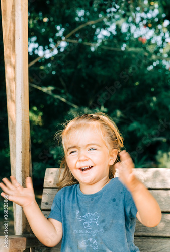 Toddler girl clapping hands on wooden bench © amelie