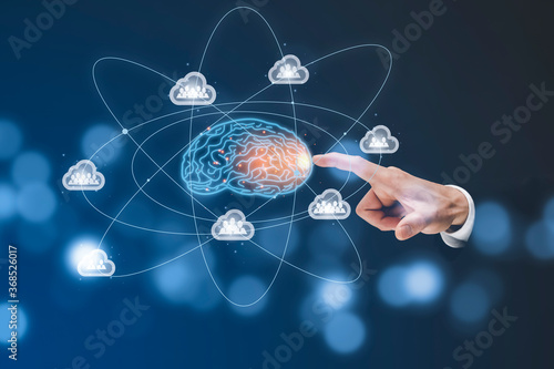 Businessman touch brain with cloud and people icon in the dark background in graph Screen Icon of a media screen, Technology Process System Business concept photo