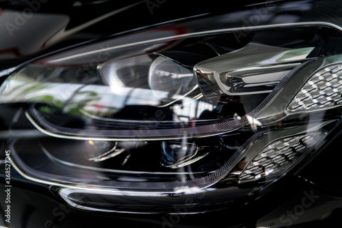 Close-up image of headlights of black premium car © Yakov