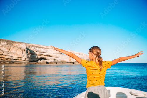 Little girl sailing on boat in clear open sea