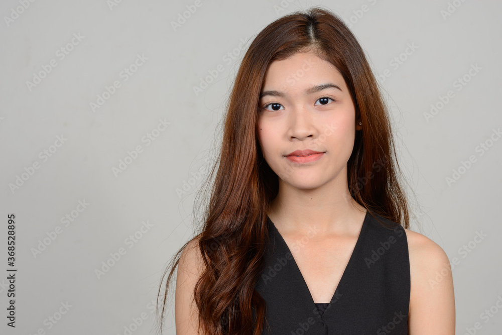 Portrait of young beautiful Asian woman against white background Portrait of young beautiful Asian woman against white background