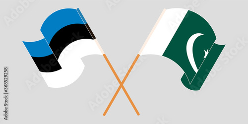 Crossed and waving flags of Pakistan and Estonia
