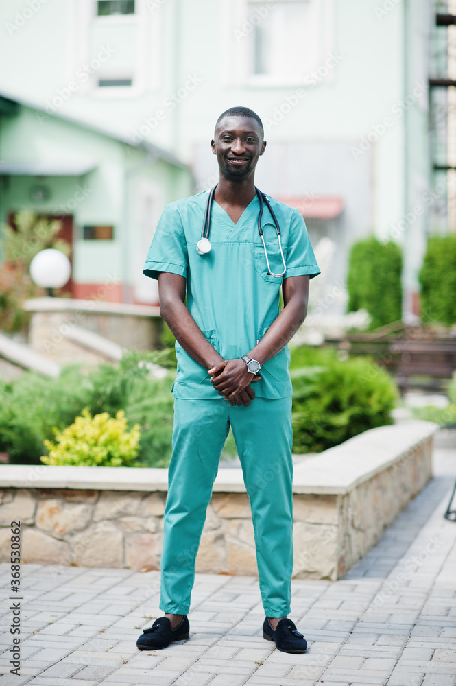 Portrait of African male doctor with stethoscope wearing green coat.