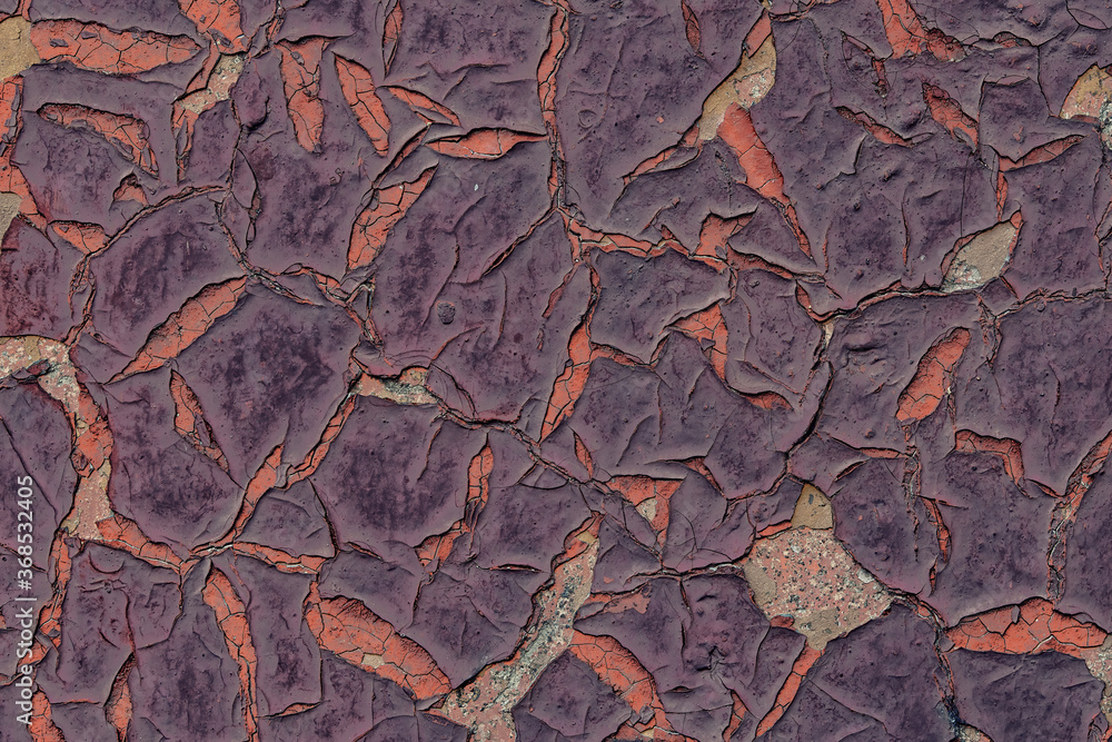 Texture of old painted wall, covered with cracks and roughness close-up. Craquelure on old surface. Violet old cracked paint background. Grunge background texture colored wall in old cracked paint