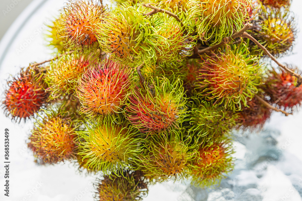 rambutan a bunch of fruit delicious fruit shaggy on a white plate close-up rambutan a bunch of fruit delicious fruit shaggy on a white plate close-up