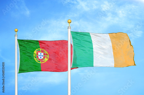 Portugal and Ireland two flags on flagpoles and blue sky