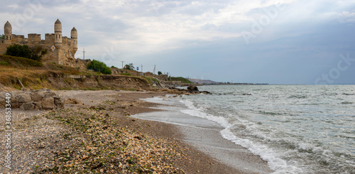 Waves and seashell. In the distance you can see the fortress of Yenikale on the shore of the Kerch Strait photo