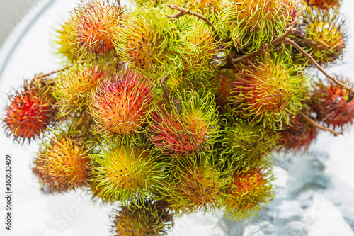 rambutan a bunch of fruit delicious fruit shaggy on a white plate close-up © Kai Beercrafter