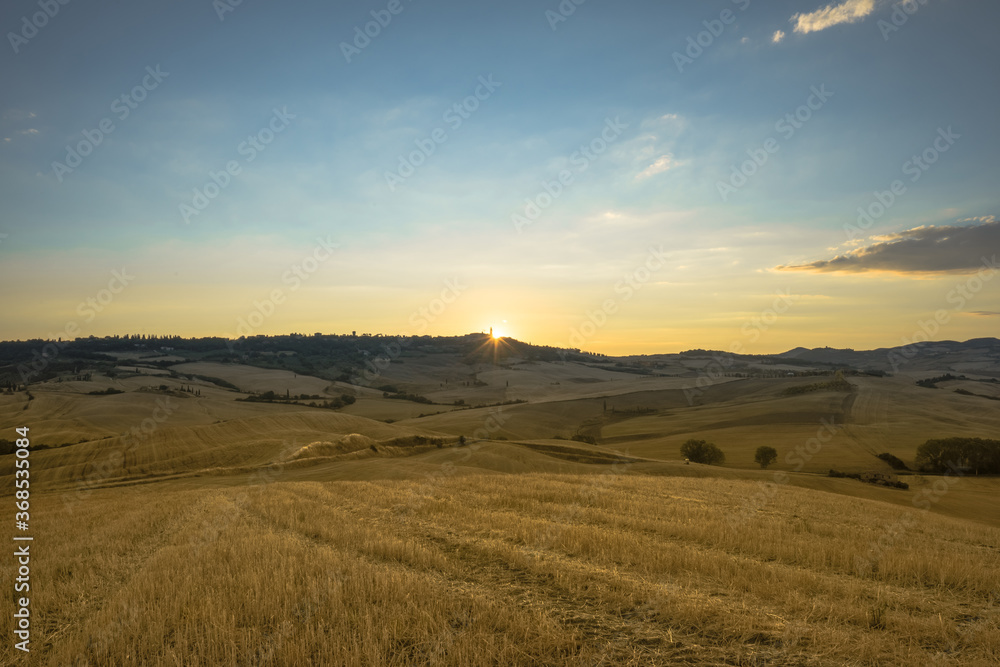 First rays of summer sunrise over Pienza, Val d'Orcia, Tuscany, Italy