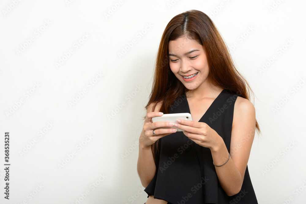 Portrait of happy young beautiful Asian woman using phone Portrait of happy young beautiful Asian woman using phone