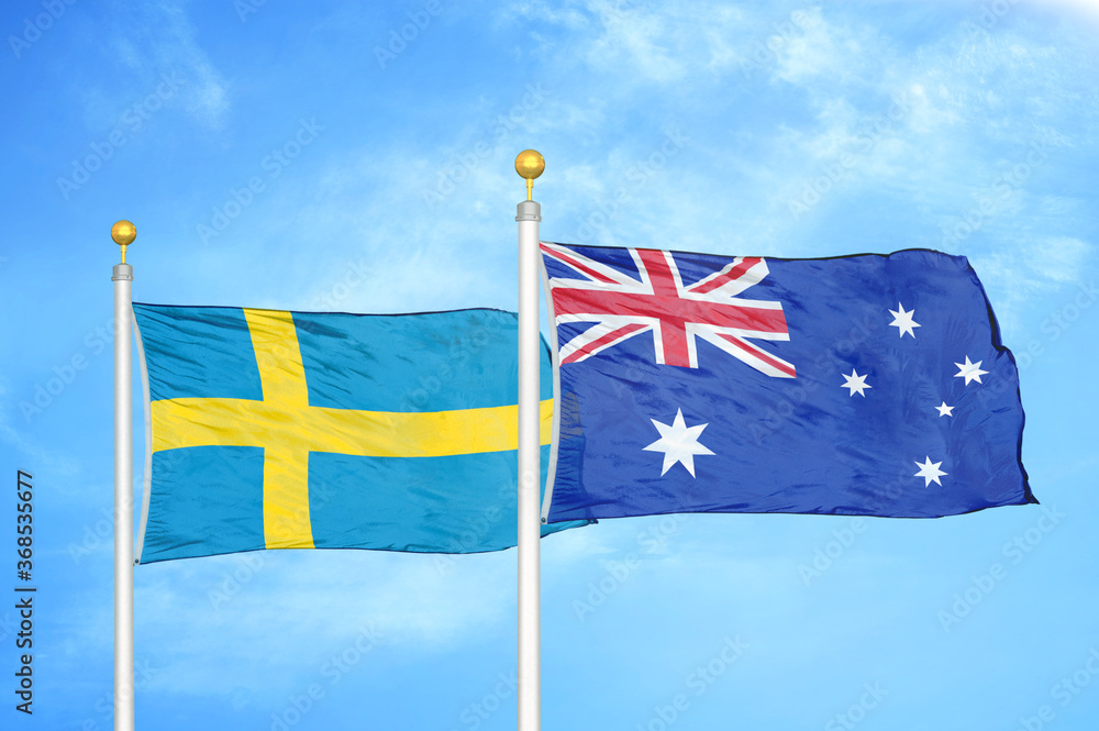 Fototapeta premium Sweden and Australia two flags on flagpoles and blue sky