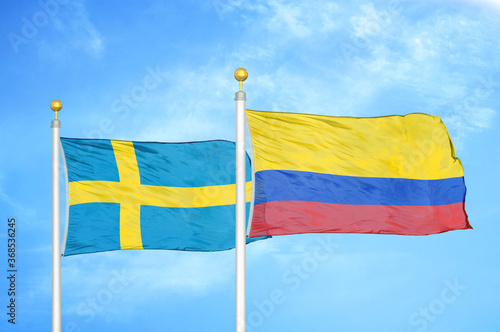 Sweden and Colombia two flags on flagpoles and blue sky