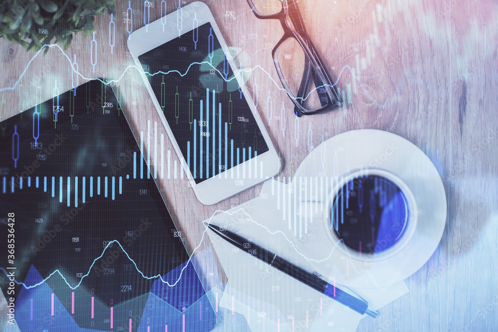 Double exposure of forex chart hologram over desktop with phone. Top view. Mobile trade platform concept. Double exposure of forex chart hologram over desktop with phone. Top view. Mobile trade platform concept.
