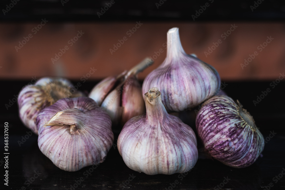 Obraz premium garlic bulb on top of a dark wooden bench