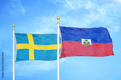 Sweden and Haiti two flags on flagpoles and blue sky