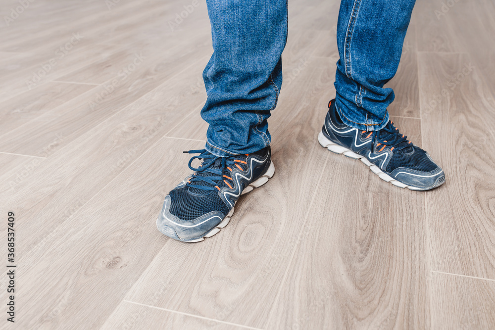 Man in jeans on a new laminate floor - wood floor decor - laminate laying master