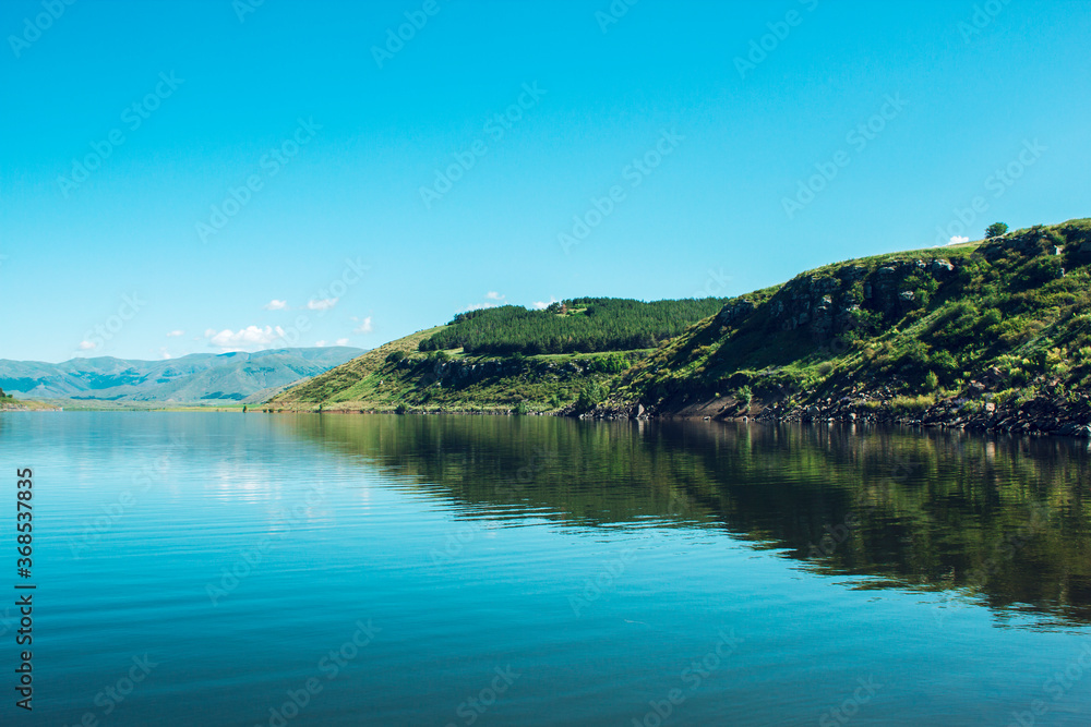 blue reservoir under blue sky blue reservoir under blue sky