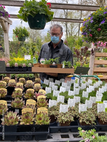 Man shopping in a garden center during the Covid-19 virus pandemic while wearing a surgical mask