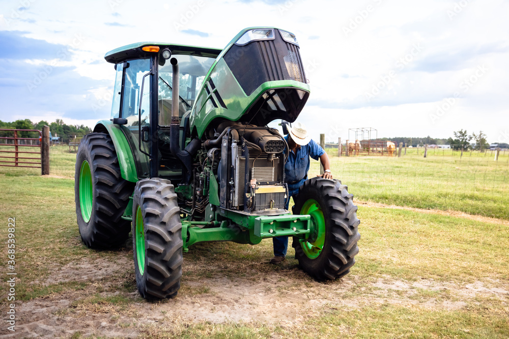 Portrait of mature man and tractor on farm Portrait of mature man and tractor on farm