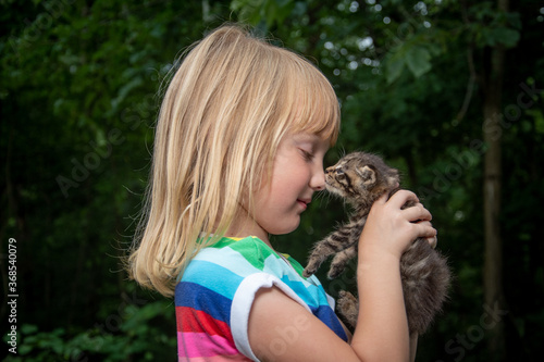 Young girl holding pet tabby kitten