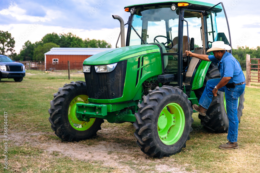 Portrait of mature man and tractor on farm Portrait of mature man and tractor on farm