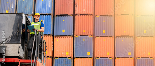 Portrait of confident inspector standing in front of containers in port, Dock worker with clipboard checking cargo freight shipping, Concept of transportation, logistics business. 21:9 wide photo