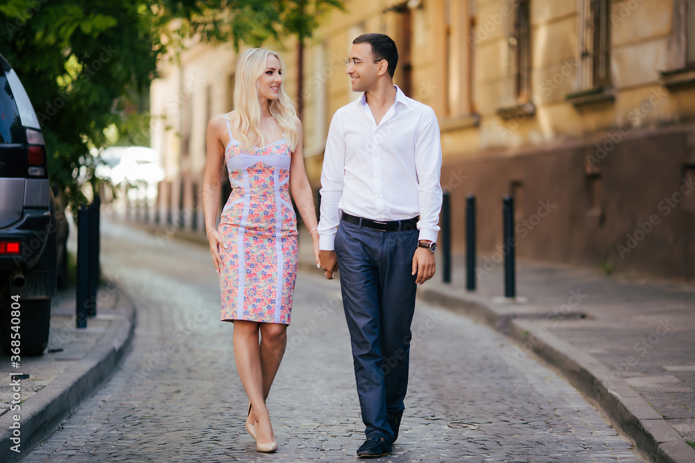 walking down the street together. Happy young man and smiling woman walking through the streets of Old Town,