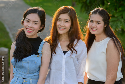 Three young Asian women as friends together at the park
