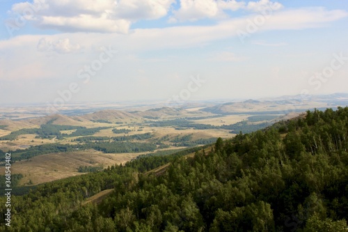 Stunning panoramic view of the mountains of the forest field. Ural mountains in the haze. Top view