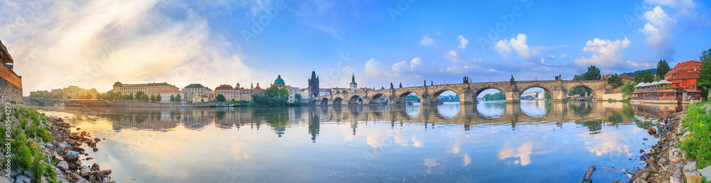 City summer landscape at sunrise - view of the Charles Bridge and the Vltava river in historical district of Prague, Czech Republic