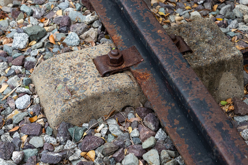 railway track of iron rails old rusty and cement sleeper against a gravel background