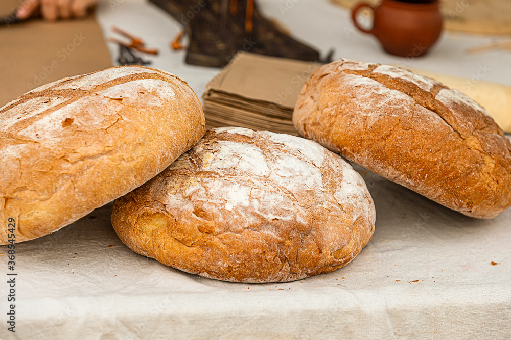 set rustic bread, freshly baked whole loaf lies on the table